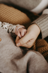 Nahaufnahme Babyhand und Erwachsenenhand ineinander